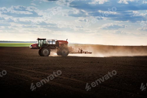 Preview: self-propelled sprayer in the field sprays arable land against the light