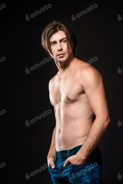 Preview: portrait of pensive shirtless man in jeans looking away isolated on black