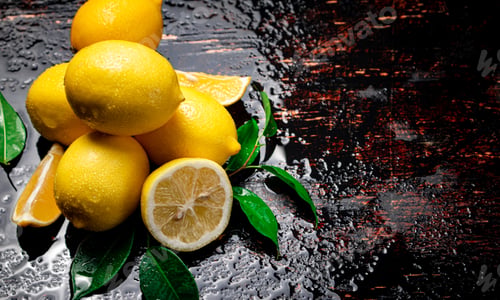 Preview: Juicy lemons with foliage on the table.