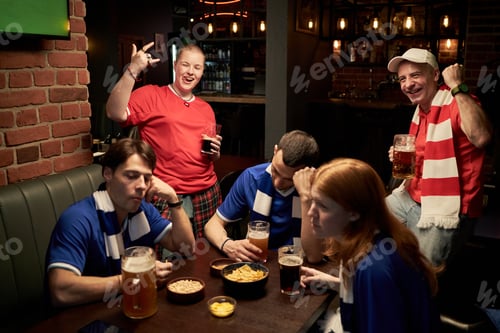 Preview: Diverse Group of Young Football Fans Reacting to Game Results in Bar