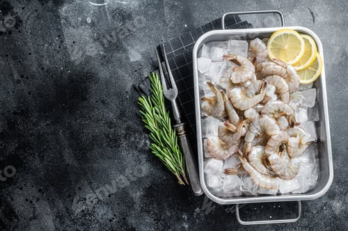 Preview: Raw pacific white shrimp prawn peeled with tail on ice. Black background. Top view. Copy space