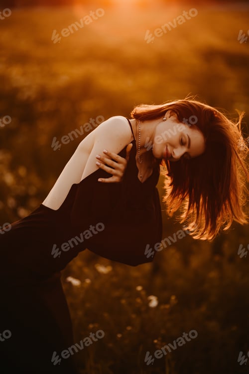Preview: An Elegant Woman Posing Gracefully in a Beautiful Field Bathed in the Warm Glow of a Sunset