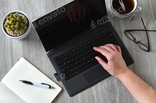Preview: Overhead view of a desk workspace with a tablet computer with keyboard and notebook