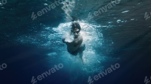 Preview: Young boy swims in the ocean with costume