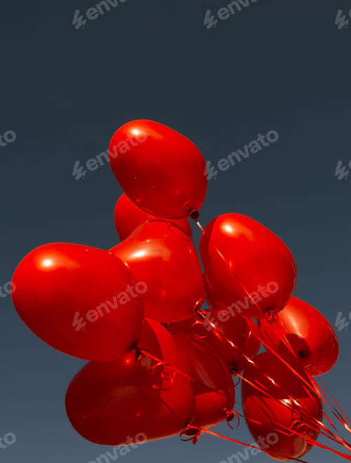 Preview: Red heart-shaped balloons against a blue cloudless sky