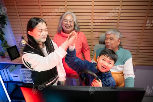 Preview: Happy grandparents playing games with grandchildren in in a neon lit room