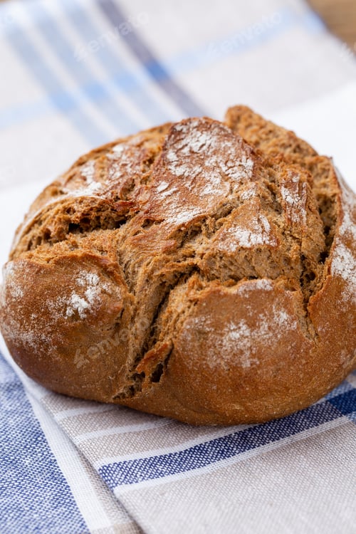 Preview: Freshly baked bread on dark gray kitchen table, top view.