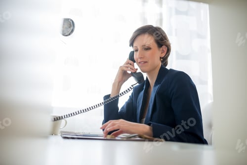 Preview: Young attractive woman wearing a blue suit smiling as she listens to the conversation