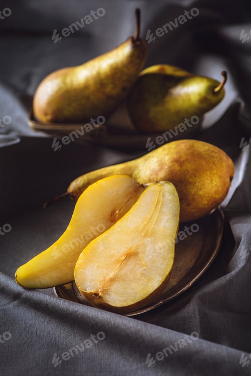 Preview: close-up shot of sliced ripe pears on grey drapery