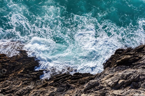 Preview: Waves crash and splash on rocks aerial top view