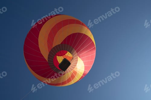 Preview: Low-angle shot of a red and yellow hot air balloon in the clear sky