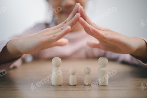 Preview: Protecting Hands Over wooden Family, Family Protection And Care Concept, family home, foster care,