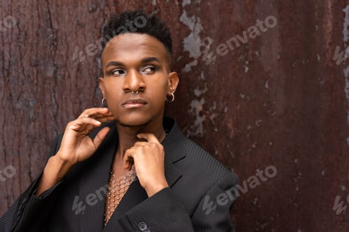 Preview: A male model of black ethnicity in a fashion pose on a brown metallic background