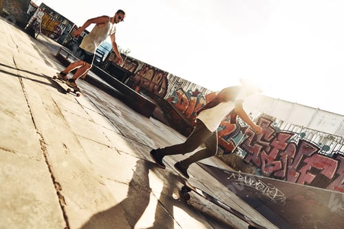 Vorschau: Coolster Stadtverkehr. Zwei junge Männer beim Skateboarden in voller Länge, während sie am Skate rumhängen