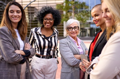 Preview: Group of business women of diverse ages walking near office building in formal clothes