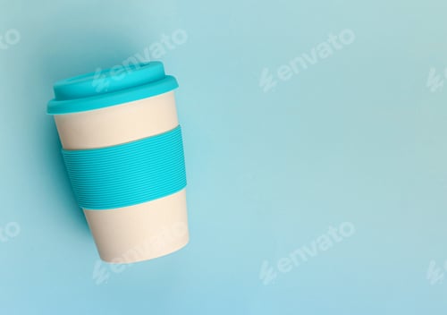 Preview: Reusable resistant plastic free bamboo cup with silicone holder on pastel blue background.