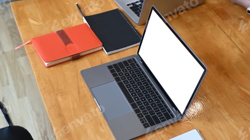 Preview: Laptop computer with empty screen and notebooks on wooden office desk.