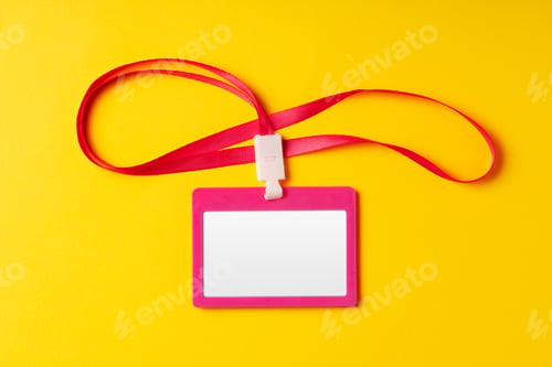 Preview: Blank nametag on a string on yellow background copy space