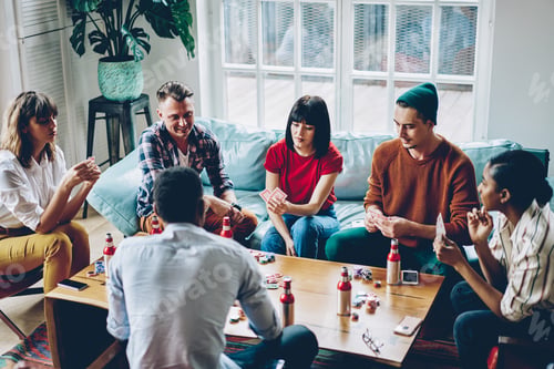 Preview: Multiracial friends playing poker during meeting