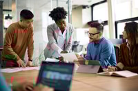 Preview: Multiracial business team analyzing reports on a meeting in the office.