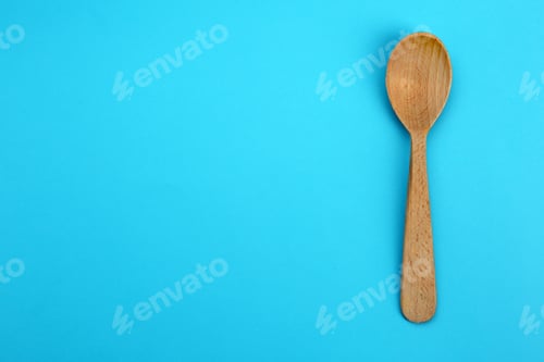 Preview: Clean empty wooden spoon on blue background, top view. Space for text