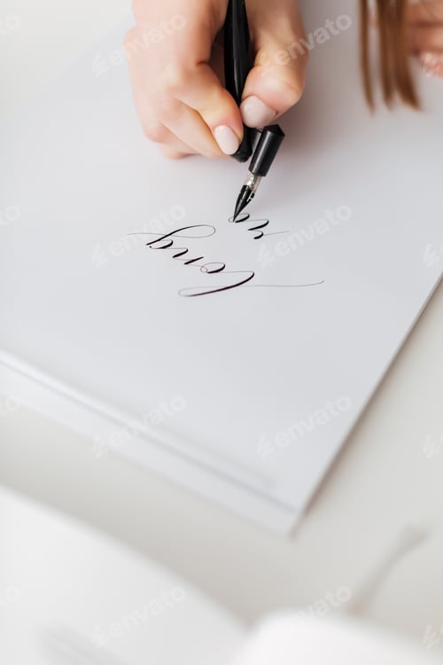 Preview: Close up photo of woman hands holding pen and writing beautiful postcard isolated