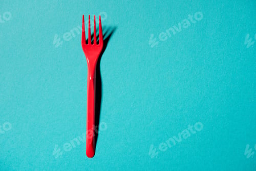 Preview: top view of red plastic fork isolated on blue
