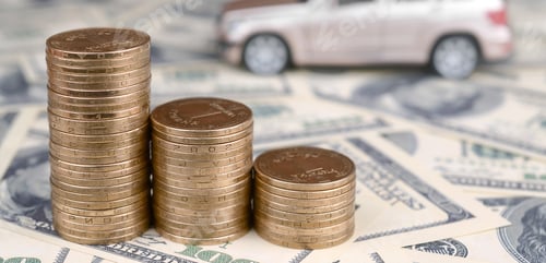 Preview: Toy car model at the stacks of golden coins lies on many dollar bills