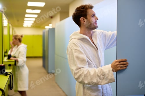 Preview: Side view of smiling man in locker room at health spa.