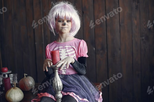 Preview: A little girl with halloween makeup on her face at home