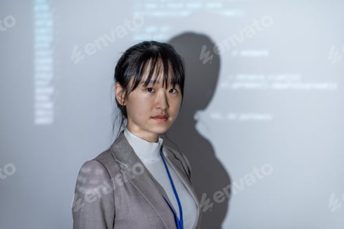 Vista previa: Young Asian businesswoman in formalwear standing by interactive whiteboard