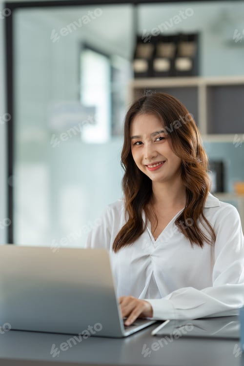 Preview: Beautiful Asian businesswoman working on a laptop computer doing financial, accounting analysis, rep