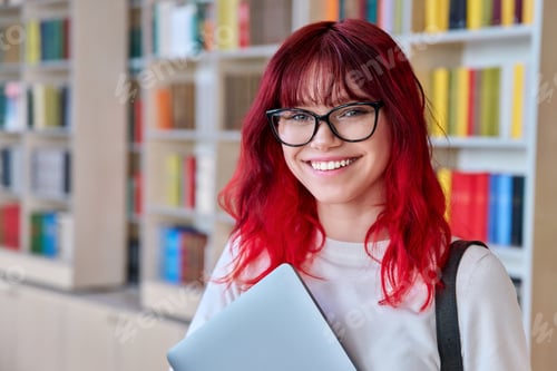 Preview: Portrait of female college student in glasses with laptop backpack, looking at camera