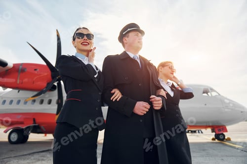 Preview: Three people. Crew of airport and plane workers in formal clothes standing outdoors together