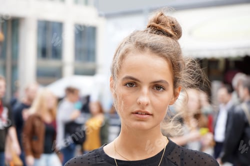 Preview: Young Woman with Hair Up Standing in City