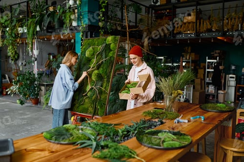 Preview: Two designers working on floral collage at florist shop