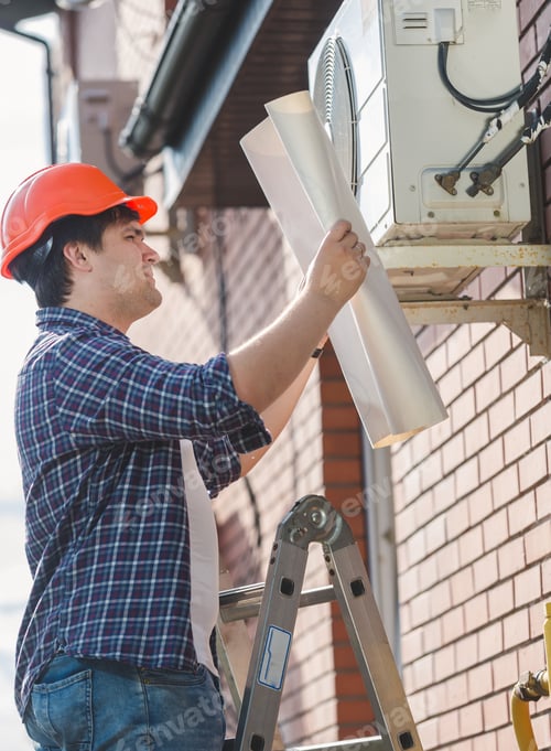 Preview: Engineer in hardhat looking in plan of air conditioning system
