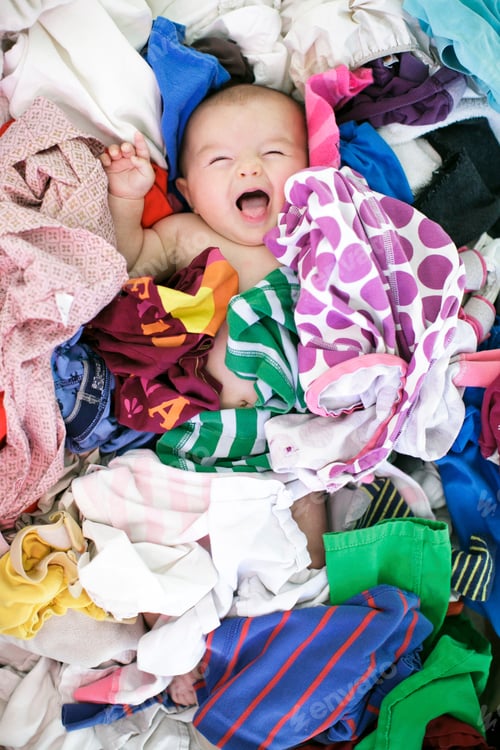 Preview: Overhead portrait of baby girl lying in laundry