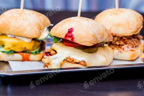 Preview: Close up three tasty burgers with different filling served on tray