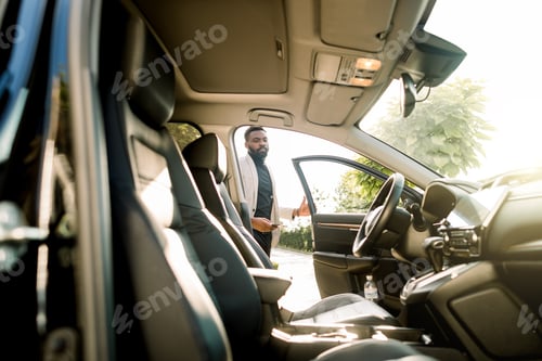 Preview: Busy African young man in suit getting in car. Happy young businessman getting inside his car