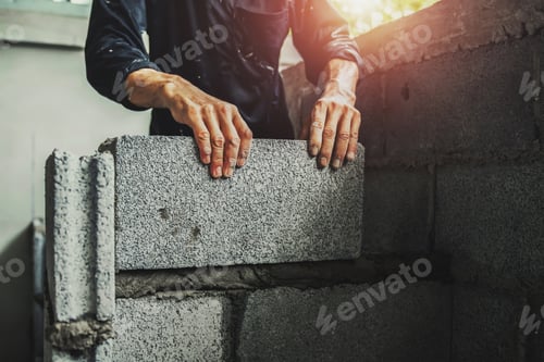 Preview: Worker building wall bricks with cement