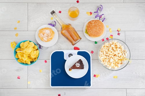 Preview: Flat lay composition with scales, different food and alcohol on floor. After party chaos