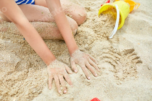 Preview: Little kid having fun on the beach and playing with sand toys