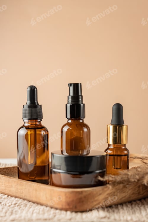 Preview: anti-aging collagen facial serum in dark glass bottle and face cream on beige background