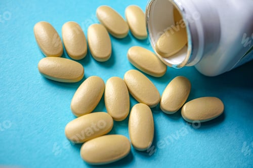 Preview: Closeup shot of painkiller pills spilling out of a dark blue vial isolated on a cyan background