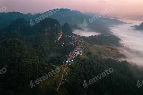 Preview: Aerial view of Morning fog and mountains with a rural village and sunrise from above