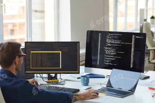 Preview: Male IT Programmer Using Computers with Code on Screen