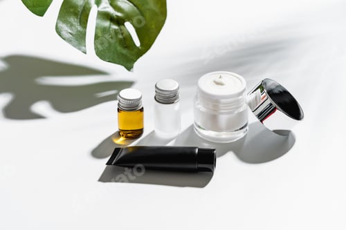 Preview: White serum bottle and cream jar, mockup of beauty product brand. Top view on the white background.