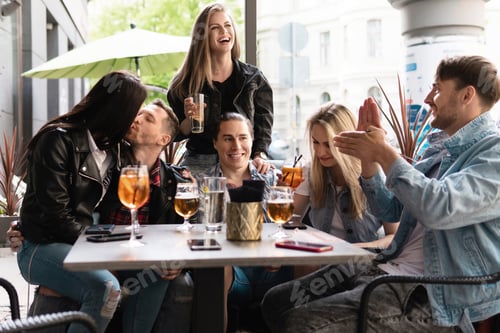 Preview: Group of friends are drinking beer and cocktails in a bar