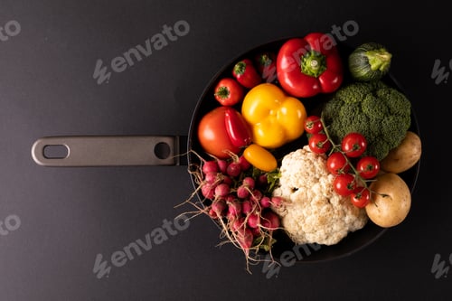 Preview: Directly above shot of various vegetables in frying pan on black background